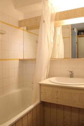 une salle de bain avec une baignoire, un lavabo et un miroir dans l'établissement P2-3 esprit chalet sur les pistes de Courchevel, à Courchevel
