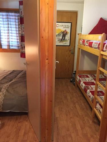 une chambre avec un lit et un lit superposé dans l'établissement P2-3 esprit chalet sur les pistes de Courchevel, à Courchevel