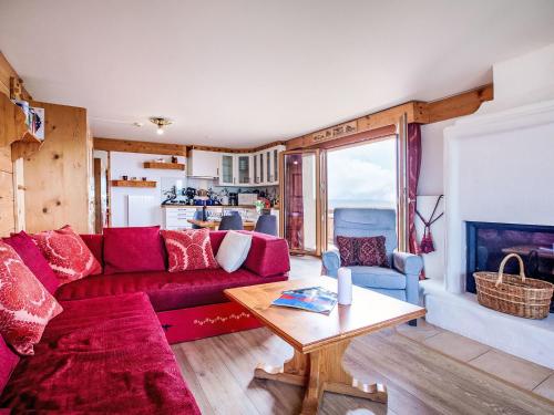 Una sala de estar con un sofá rojo y una mesa. en Apartment Le Bristol A52 by Interhome, en Villars-sur-Ollon