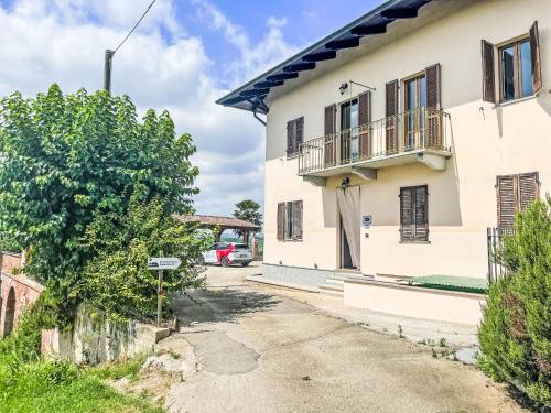 a white house with a balcony and a driveway at Holiday Home Zio-Nonno by Interhome in Portacomaro