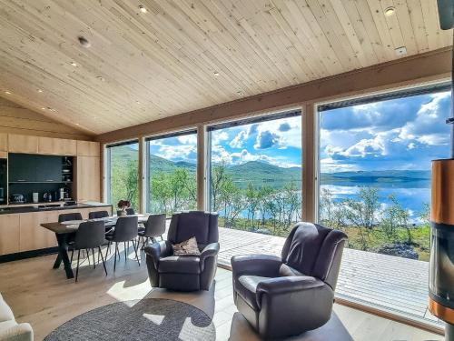 a living room with a table and chairs and a large window at Holiday Home Loimu by Interhome in Kilpisjärvi