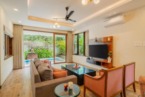 a living room with a couch and a tv at ELIVAAS 3 BHK Pvt Pool & Bar - Villa Valerie in Oxel