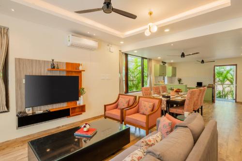a living room with a couch and a tv at ELIVAAS 3 BHK Pvt Pool & Bar - Villa Valerie in Oxel