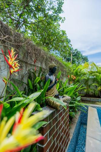a statue sitting on a brick wall next to a swimming pool at ELIVAAS 3 BHK Pvt Pool & Bar - Villa Valerie in Oxel