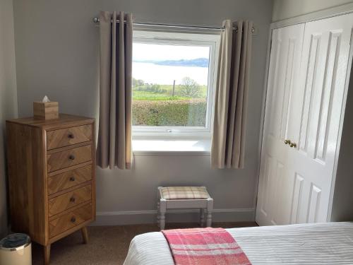 a bedroom with a bed and a window and a dresser at Holiday Home Tigh Grianach by Interhome in Connel