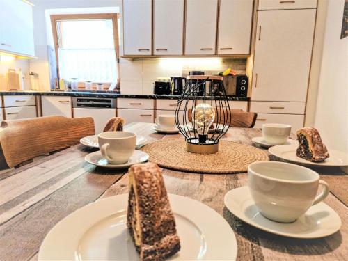 a kitchen with a wooden table with cups and saucers at Apartment Wandegg by Interhome in Ginzling