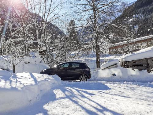 a car is parked in a snow covered yard at Apartment Wandegg by Interhome in Ginzling