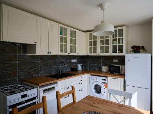 a kitchen with white cabinets and a white refrigerator at Apartment Harrachov 582 by Interhome in Harrachov