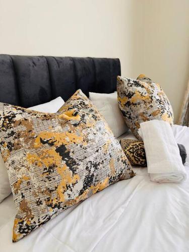 a bed with some pillows on top of it at Tetani's Luxury Oasis in Lakeside