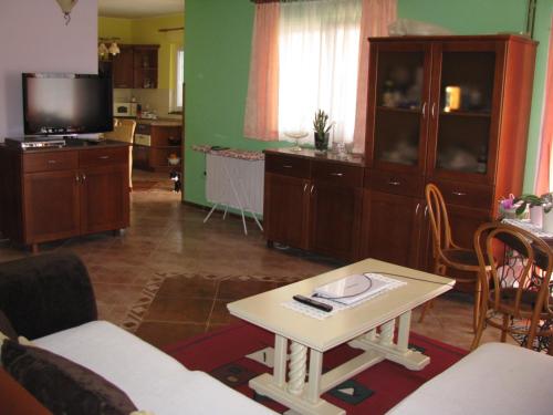 uma sala de estar com uma mesa e uma televisão em Apartment Megi em Tribunj