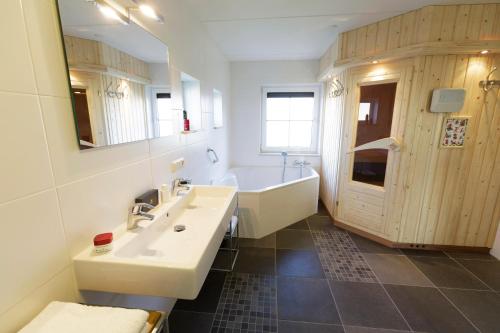 a bathroom with a tub and a sink and a bath tub at Center Parcs Sandur Emmen in Emmen