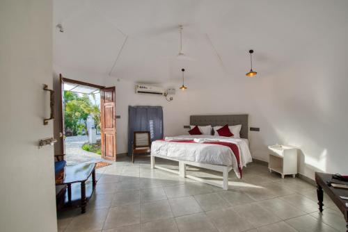 a bedroom with a bed and a door to a yard at Le Epic Resort in Virāmpattinam
