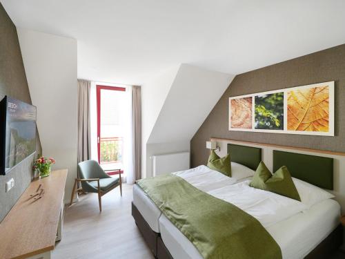 a bedroom with a bed and a desk and a chair at Apartment Beech Resort Plauer See by Interhome in Ganzlin