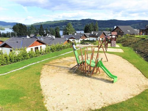 a playground with a green slide in a park at Holiday Home Residence Lipno-9 by Interhome in Lipno nad Vltavou