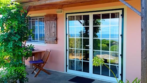 an open door to a patio with a chair at Faial Cottage B&B in Cedros