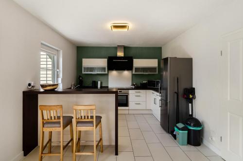 a kitchen with two chairs and a counter with a refrigerator at Ferienhaus Wiesmoor in Wiesmoor