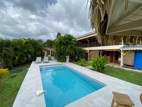 a swimming pool in front of a house at Colibri Villa Sainte Luce in Sainte-Luce