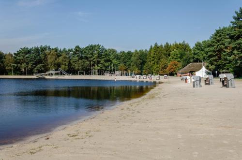 a beach with chairs and a building and water at Ferienhaus Wiesmoor in Wiesmoor