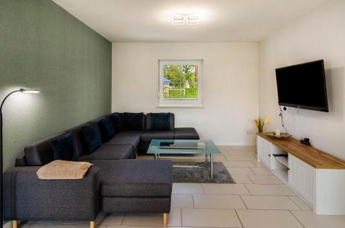a living room with a couch and a tv at Ferienhaus Wiesmoor in Wiesmoor