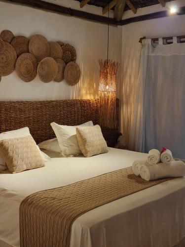 a bedroom with a bed with two towels on it at Pousada Vila do Mar in Caraíva