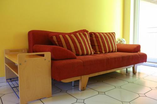 a red couch with two pillows in a living room at Ferienwohnungen Porisch in Egloffstein