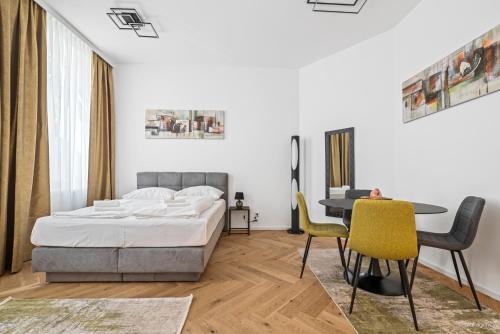 a bedroom with a bed and a table and chairs at easy-flat Rokitanskygasse - Apartments near Tram 43 to City Center in Vienna