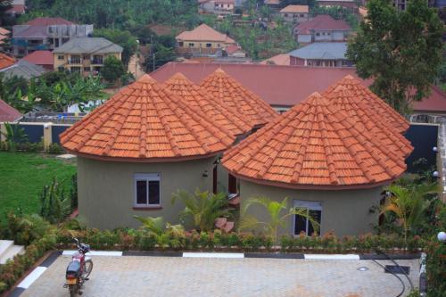 a house with an orange roof with a motorcycle parked in front at Nesa Resort Kampala in Kampala