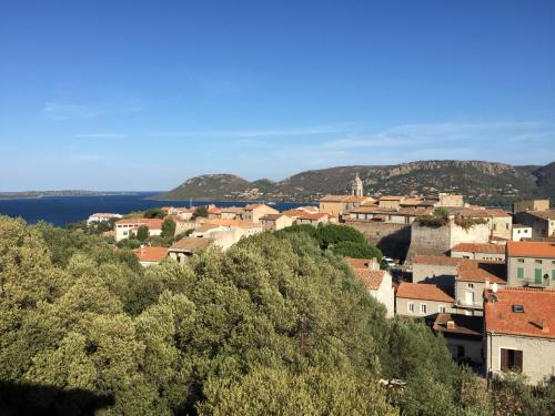 a town on top of a hill with a body of water at Citta di Lume Suites & Lofts in Porto-Vecchio