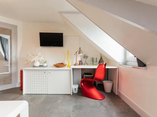 Cette chambre comprend un bureau et une chaise rouge. dans l'établissement Apartment Rossini by Interhome, à Trouville-sur-Mer