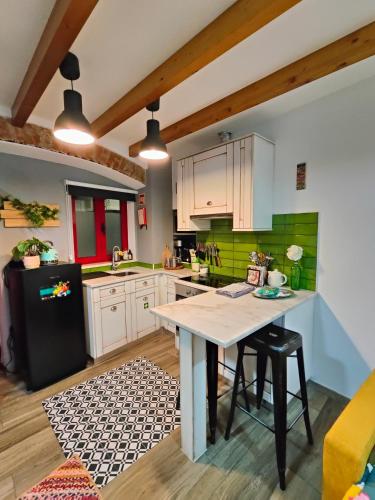 a kitchen with a table and a black refrigerator at Azoka by the Sea- Centro Histórico de Peniche in Peniche