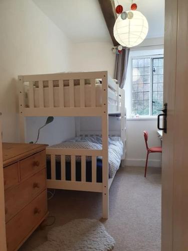 a childs bedroom with a bunk bed and a dresser at River cottage Dartmoor in Holne
