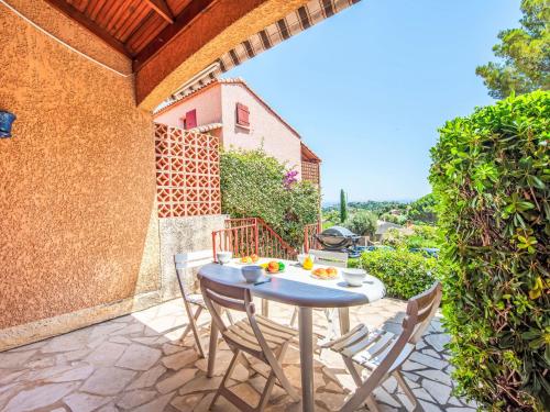 un patio avec une table et des chaises sur un patio dans l'établissement Studio Les Villas de Cavalaire-2 by Interhome, à Cavalaire-sur-Mer