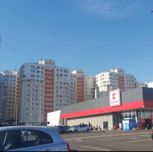 a parking lot with cars parked in front of a building at Уютная квартира в центре in Sectorul Botanica