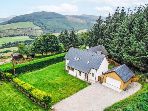 an aerial view of a white house on a green field at Holiday Home Springbank Lodge by Interhome in Drumnadrochit