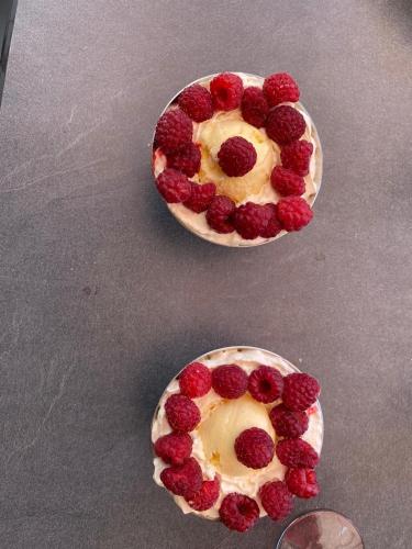 two plates with raspberries on them on a table at Auberge Restaurant les Aiguilles Rouges in Hérémence