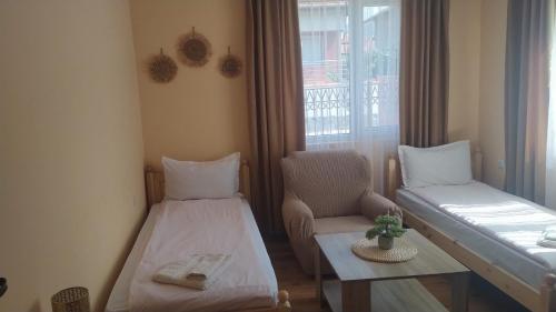 a room with a bed and a chair and a window at Holiday guest house KEMO in Sapareva Banya