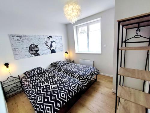 une chambre avec un lit noir et blanc et une fenêtre dans l'établissement Le Vign'Art, à Bergheim