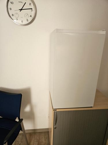 a white refrigerator and a clock on a wall at Krämerbrückenidyll in Erfurt
