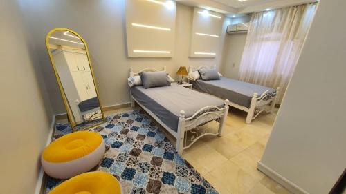 a room with two beds and a mirror at شقة فاخرة لعائلة بالمهندسين in Cairo