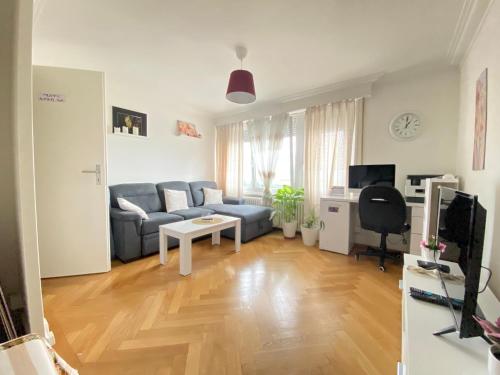 a living room with a couch and a table at Studio charmant centré à Lausanne in Lausanne