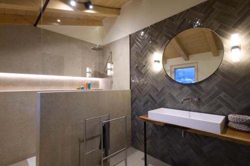 a bathroom with a sink and a mirror at GardaZen Suites - luxury - adults only in Caprino Veronese