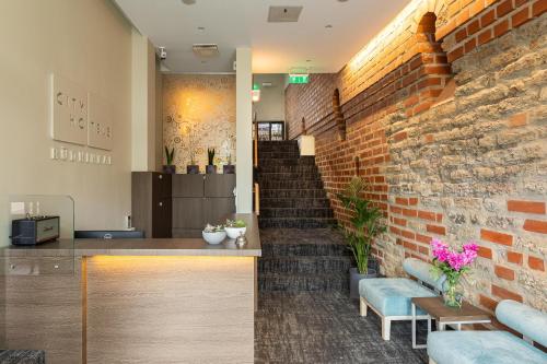 a lobby with a brick wall and a staircase at City Hotels Rūdninkai in Vilnius