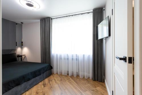 a bedroom with a bed and a large window at NEW!!!Новая двухкомнатная квартира в самом центре города in Mykolaiv
