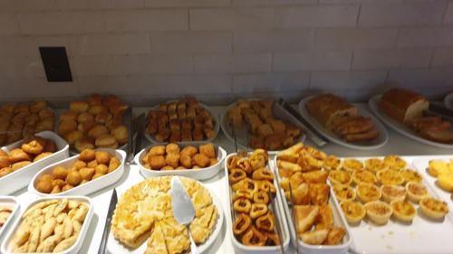 a buffet of different types of donuts and pastries at Hotel das Palmeiras in Paracatu