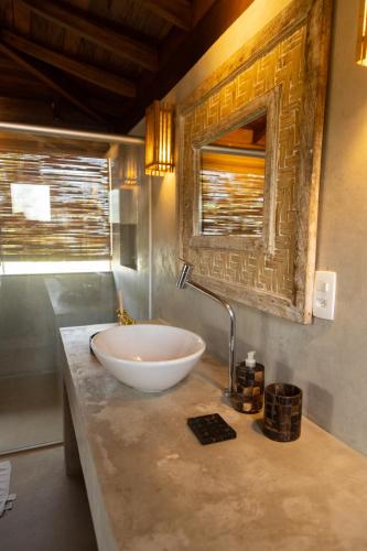 a bathroom with a sink and a mirror on a counter at Pousada Vila do Mar in Caraíva