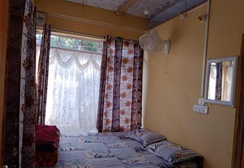 a bedroom with a window and a bed in front of it at Odyssey Stays Mawlynnong in Mawlynnong