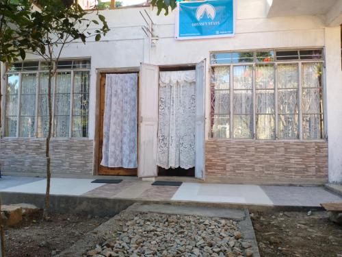 a building with doors and windows and a tree at Odyssey Stays Mawlynnong in Mawlynnong