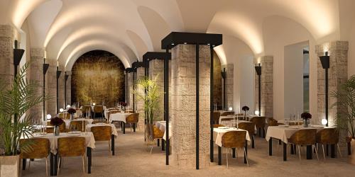 un restaurante con mesas y sillas en una sala con techos en Le Grand Hôtel Dieu by SOWELL COLLECTION, en Nimes