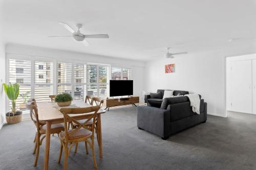 a living room with a couch and a table at Seashells Sweet Retreat 450m walk to CBD in Nelson Bay