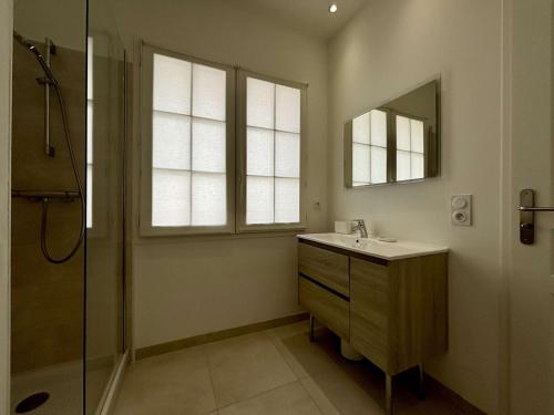 une salle de bain avec un lavabo, une douche et un miroir dans l'établissement Maison rénovée avec cour, 6 pers, Saint-Denis-d'Oléron - FR-1-246A-332, à Saint-Denis-dʼOléron